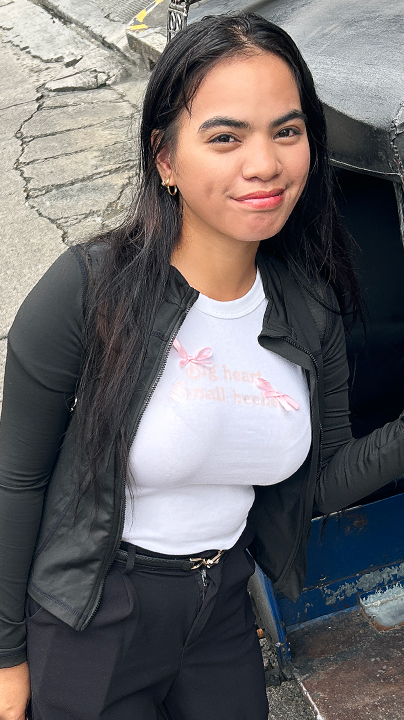 Joyful Filipina Trike Patrol Gab Dias poses next to trike in Manila